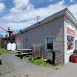 Small gas station convenience store with washroom and outdoor seating in Wollaston, Ontario.