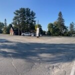 Empty gas station lot with fueling area and surrounding trees in Ontario.